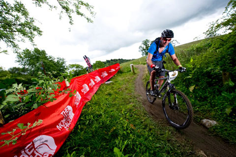 photograph of a mountain biker coming towards the camera on a trail
